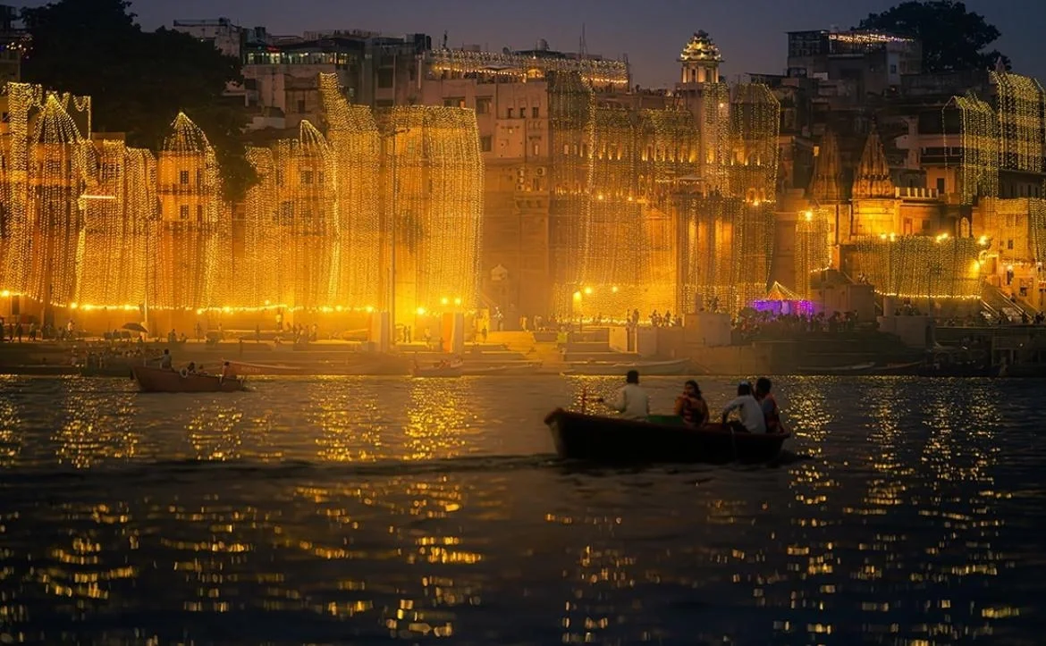 A festive boat passing illuminated Varanasi ghats during Dev Diwali