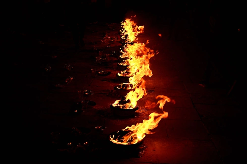 Ceremonial flames and floating lamp offerings moving along the Ganga at night