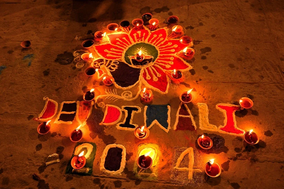 An intricate rangoli surrounded by glowing diyas